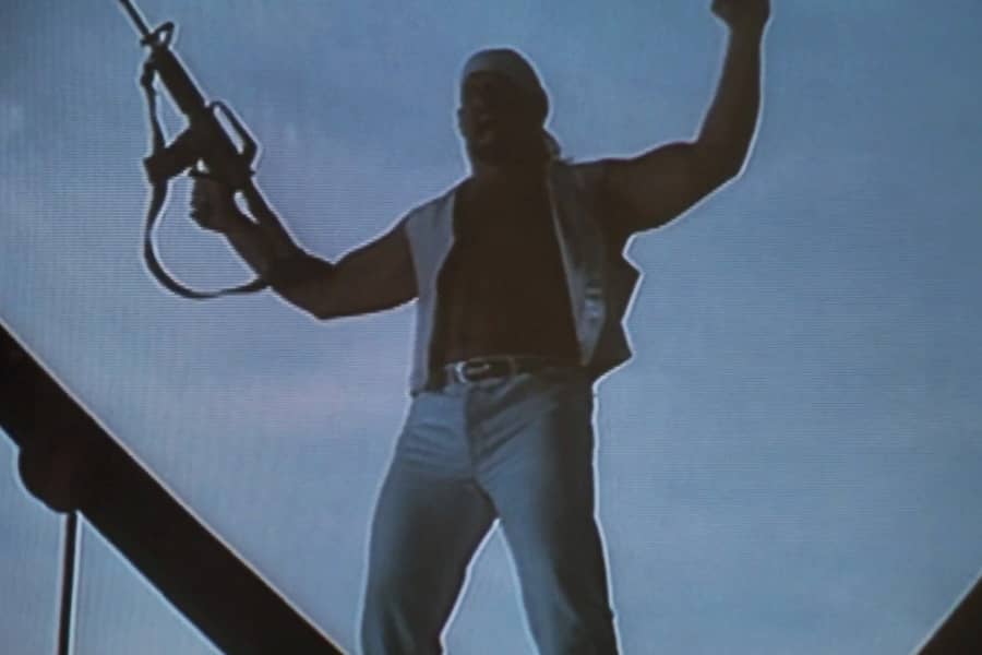 Ventura cheering with his arms raised holding a gun