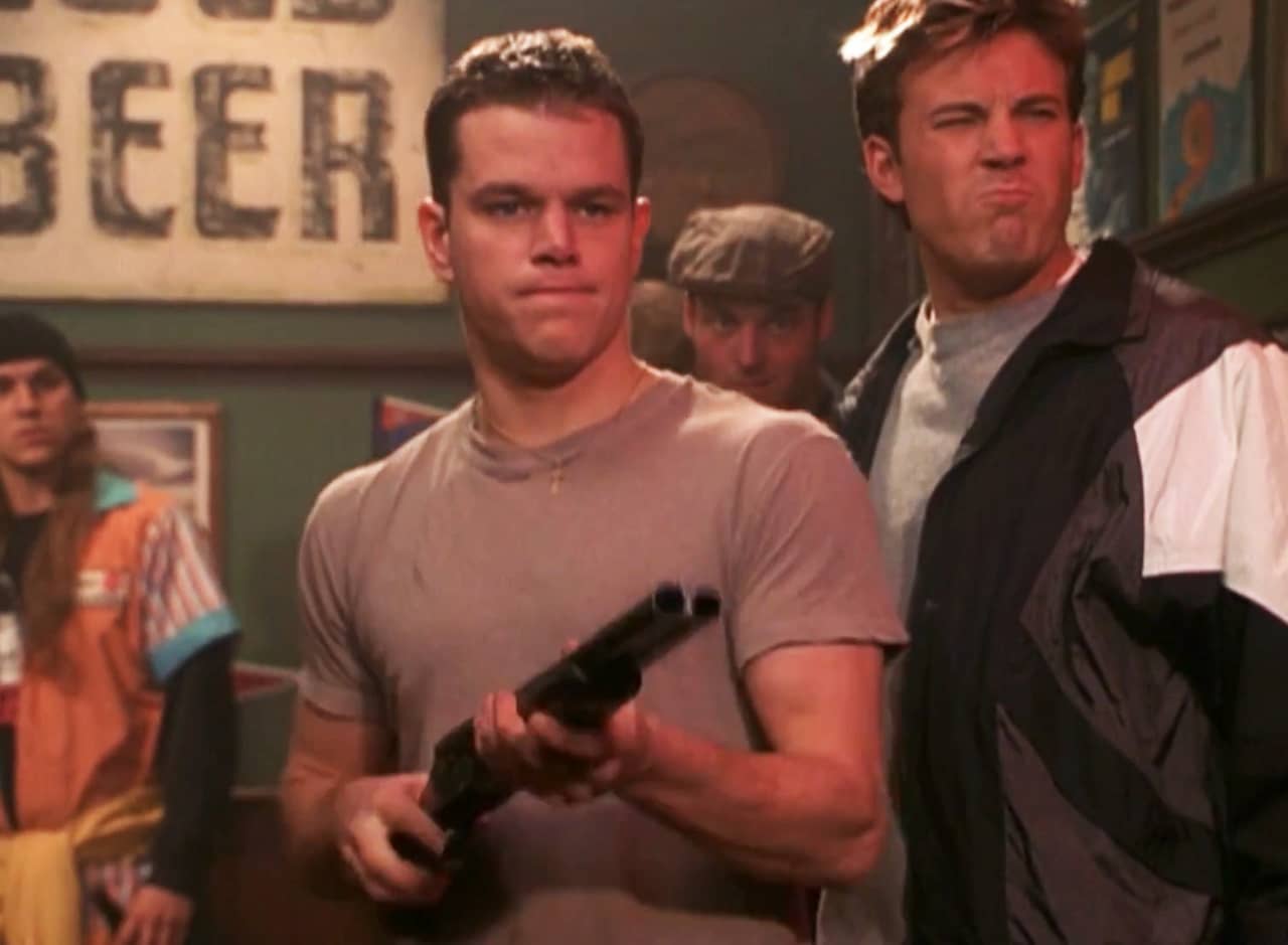 Will (Matt Damon) holds a gun and Chuckie (Ben Afflec) makes a squinty face